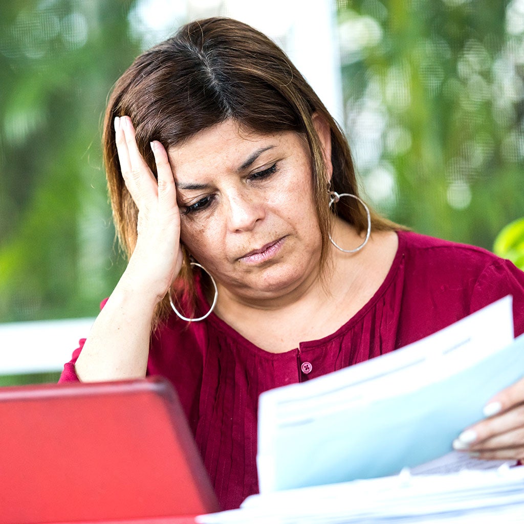 Woman reading bills, looking concerned