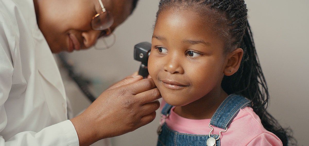 Little girl has her ears checked by physician