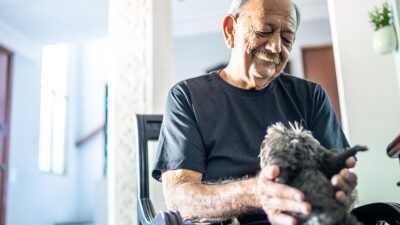 Elderly man petting his dog