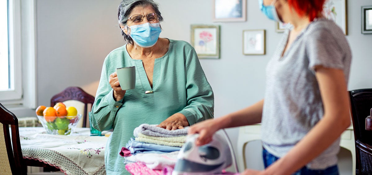 young woman helps older woman with laundry