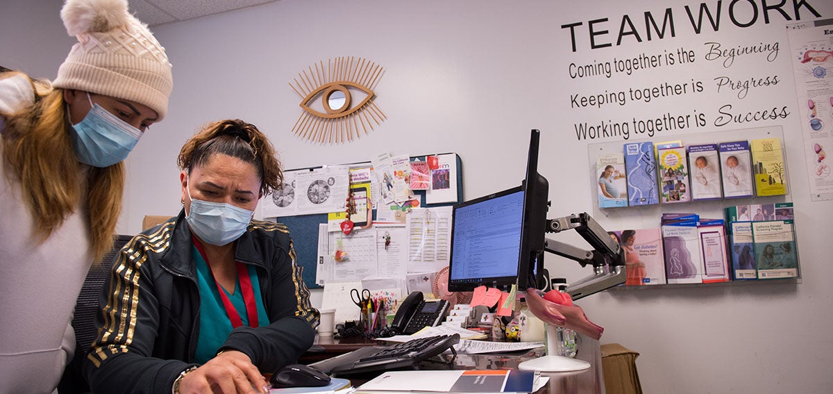 Women in health clinic look at paperwork together