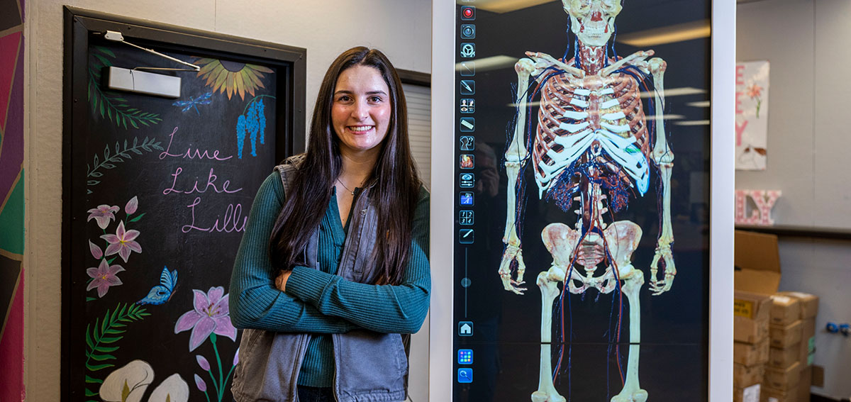 rural health worker shortage - Young woman poses with computerized training equipment for future health care workers 