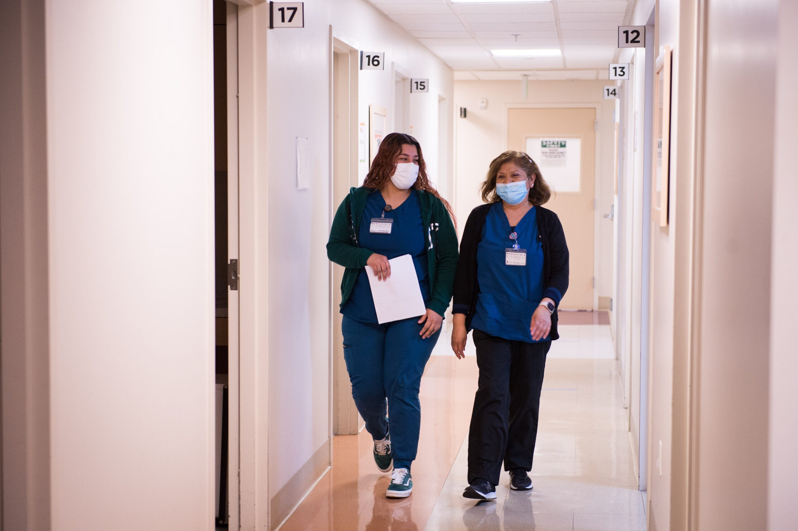 MA Eva Medrano, left, and MA Rebecca Hernandez, right, walk down the hall together in the family practice area at QueensCare Clinic in East Los Angeles

(Jessica Brandi Lifland/CHCF)